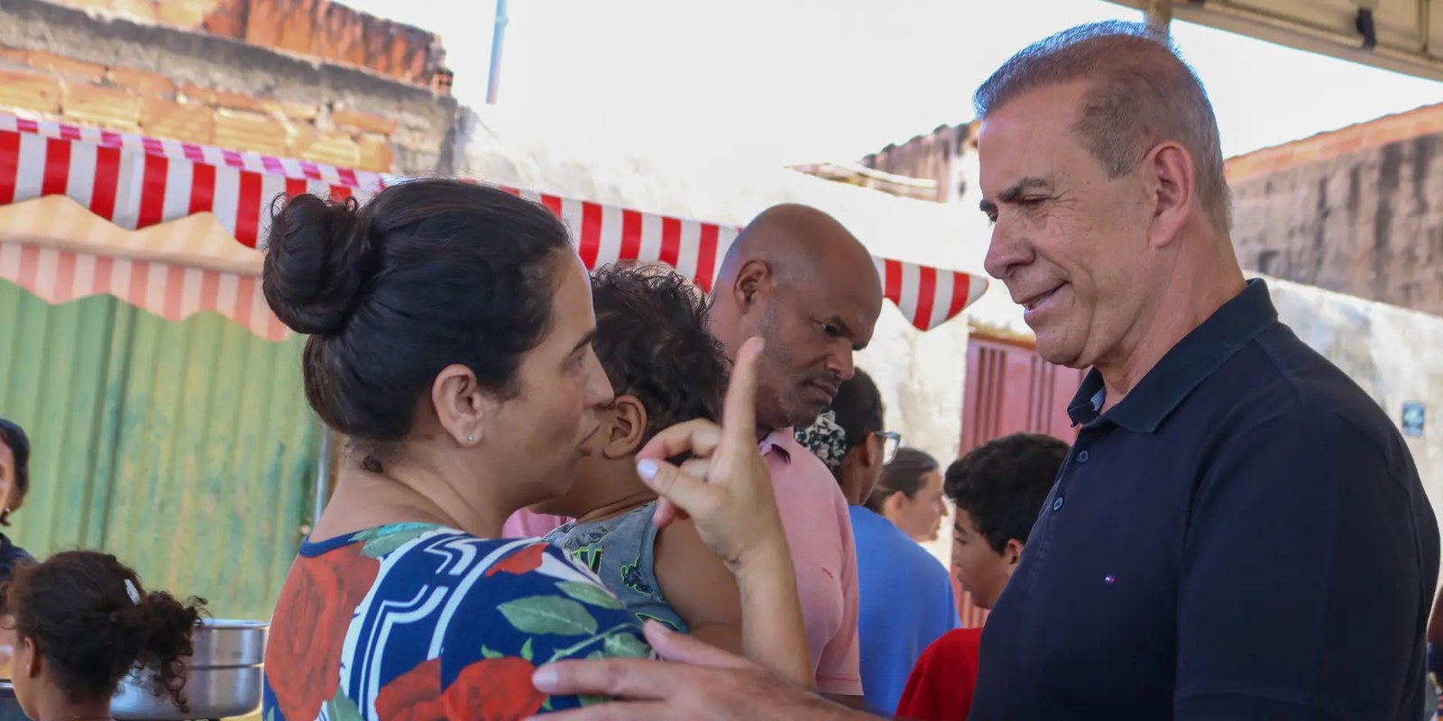 Carlão da Fox conversando com uma mãe e seu filho durante visita em Goiás